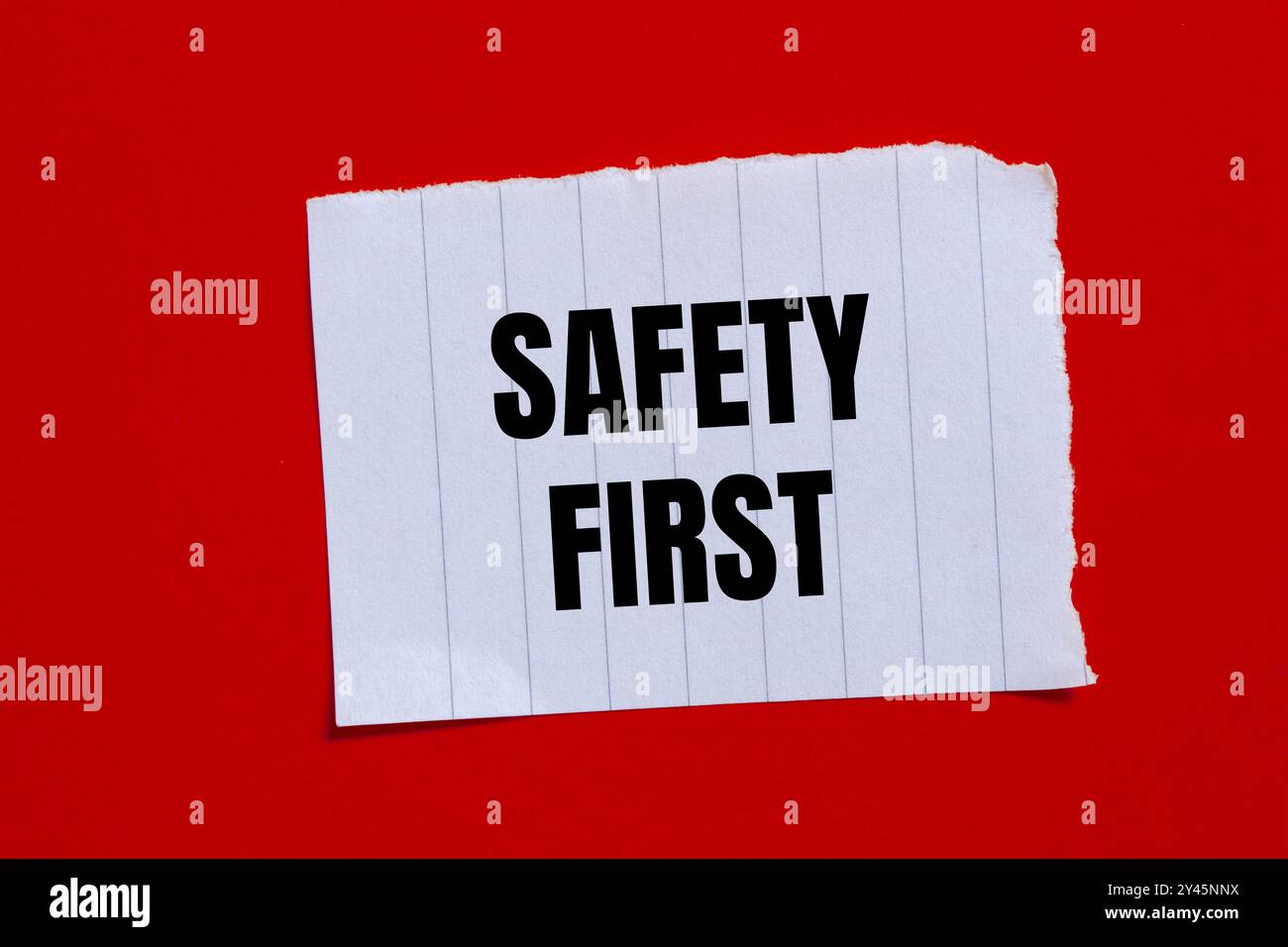 Sicherheitsmeldung auf gerissenem Papierstück mit rotem Hintergrund. Symbol für konzeptionelle Sicherheit an erster Stelle. Kopierbereich. Stockfoto