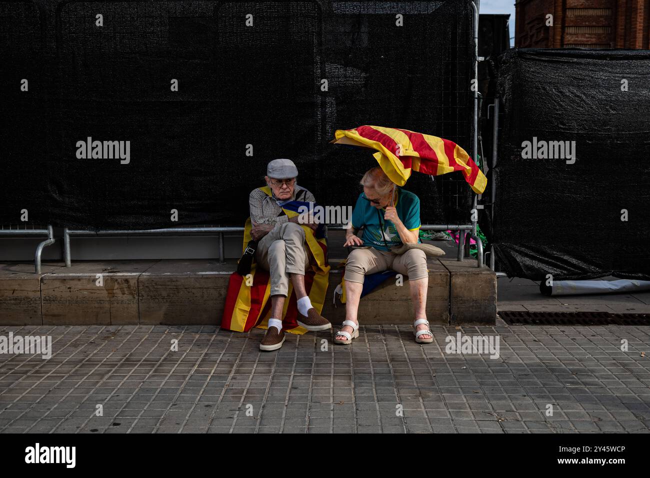 Kataloniens Nationalfeiertag in Barcelona, Spanien Ein Paar sitzt mit katalonischen Fahnen auf der Diada von Katalonien oder Kataloniens Nationalfeiertag, der am 11. September 2024 in Barcelona, Spanien, gefeiert wird. Die Diada von Katalonien, die am 11. September stattfand, erinnert an den Fall Barcelonas 1714 während des Spanischen Erbfolgekrieges und symbolisiert Kataloniens Kampf für politische Rechte und kulturelle Identität. Wie jedes Jahr im Jahr 2024 findet der Tag institutionelle Zeremonien, politische Demonstrationen statt, die sich für mehr Autonomie oder Unabhängigkeit einsetzen, und kulturelle Veranstaltungen, die das katalanische Erbe feiern. Nebeneinander Stockfoto