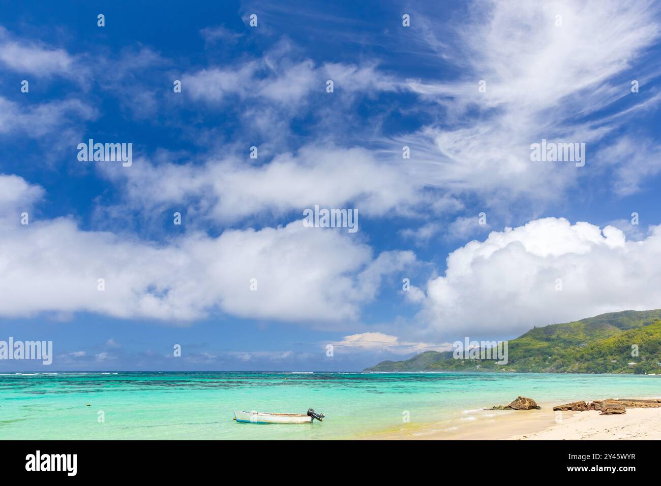 Anse Royale Beach, Seychellen. Blick auf die Küste mit einem kleinen Motorboot unter blauem Himmel an einem sonnigen Tag Stockfoto