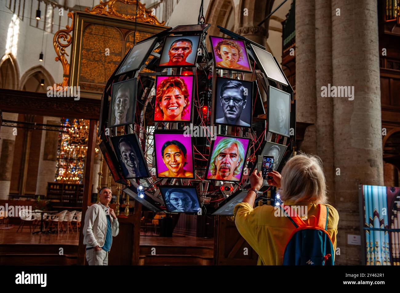 Leiden, Niederlande. September 2024. Ein Mann wird gesehen, wie er ein Foto von den Bildschirmen macht. Diese Tech-Art-Installation versetzt die Zuschauer in eine dystopische Zukunft, in der die Realität durch die Linse der statistischen Interpretationen künstlicher Intelligenz gespalten wird. Der niederländische Tech-Künstler Matthias Oostrik will das Publikum kritisch über Technologie und Vorurteil der Perfektion nachdenken lassen. Quelle: SOPA Images Limited/Alamy Live News Stockfoto