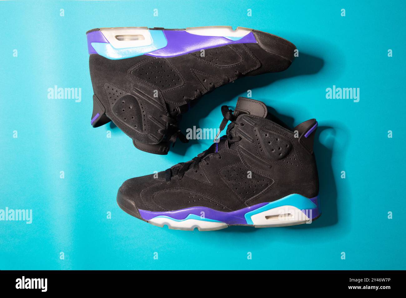 Eine wunderschöne Aufnahme des Nike Air Jordan 6 Retro Aqua Basketballschuhs auf einem einfarbigen türkisfarbenen Hintergrund, Studioaufnahme, Ansicht von oben Stockfoto