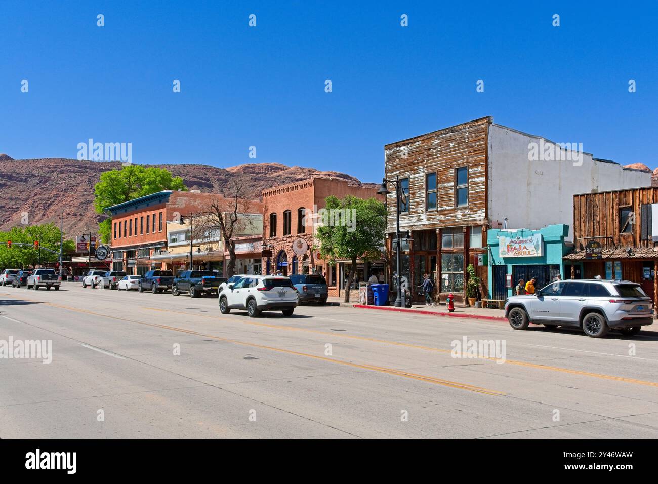 Kommerzielle Straßenlandschaft in der Innenstadt mit rotem Moab-Rand-Klippen im Hintergrund – Moab Utah, April 2024 Stockfoto