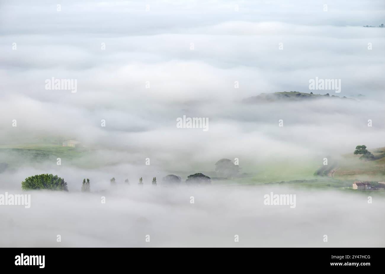 Dicker Morgennebel wirbelt und rollt auf den Somerset Ebenen wie Wellen, von den Mendip Hills aus gesehen, Somerset, Großbritannien, mit Gebieten nur Stand Stockfoto