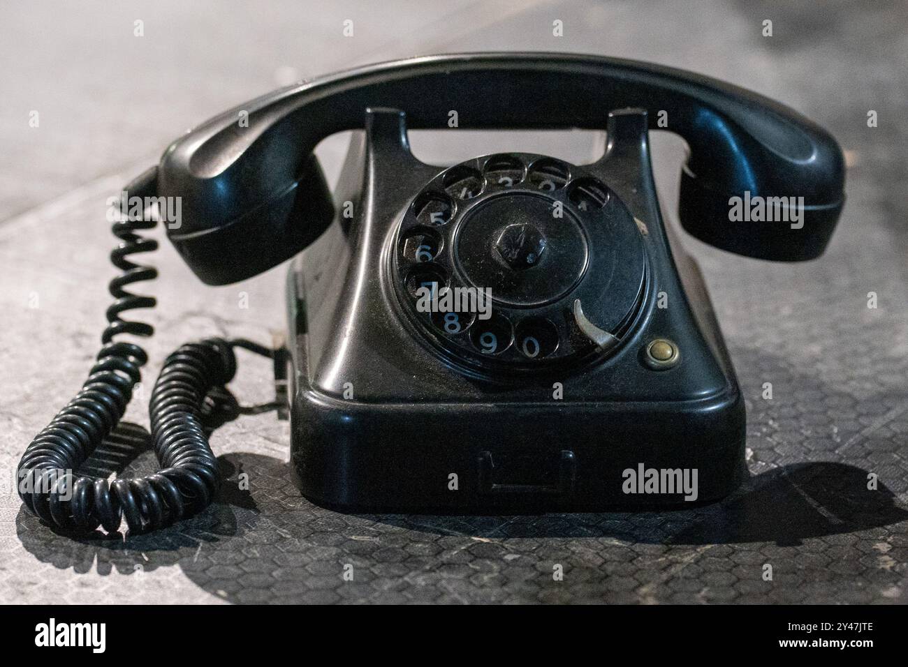 Schwarzes Retro-Telefon am Boden: Wählen Sie meine Nummer, Weckrufkonzept. Stockfoto