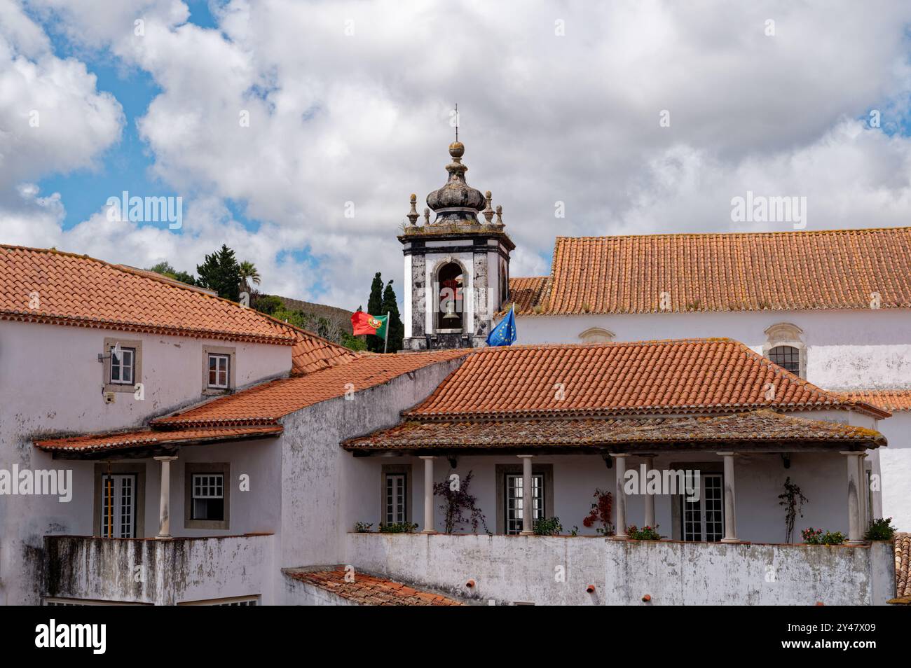 Glockenturm und Terrakotta-Dächer vor hellem Himmel in der historischen Stadt Óbidos Stockfoto