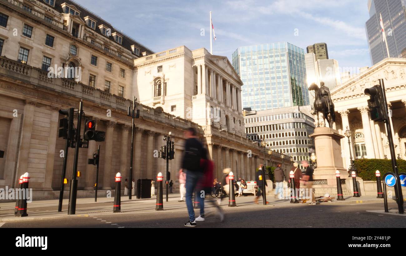 Das Gebäude der Bank of England mit Trafik und Fußgängern, die an der Bank vorbeiziehen Stockfoto