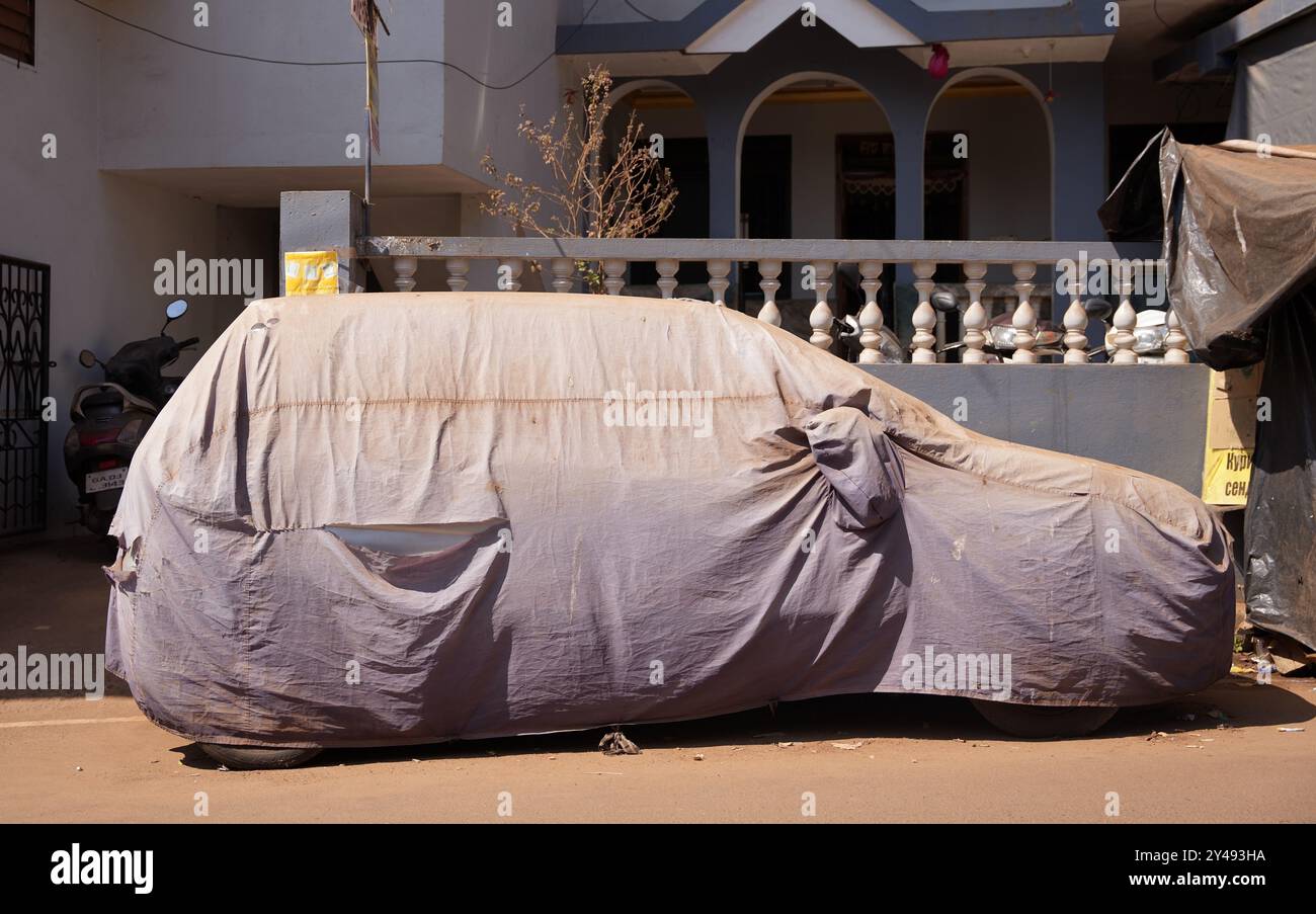 GOA, Indien - 22. Februar 2024: Auf der Straße in der Nähe des Hauses steht ein Auto mit einer Markise. Stockfoto