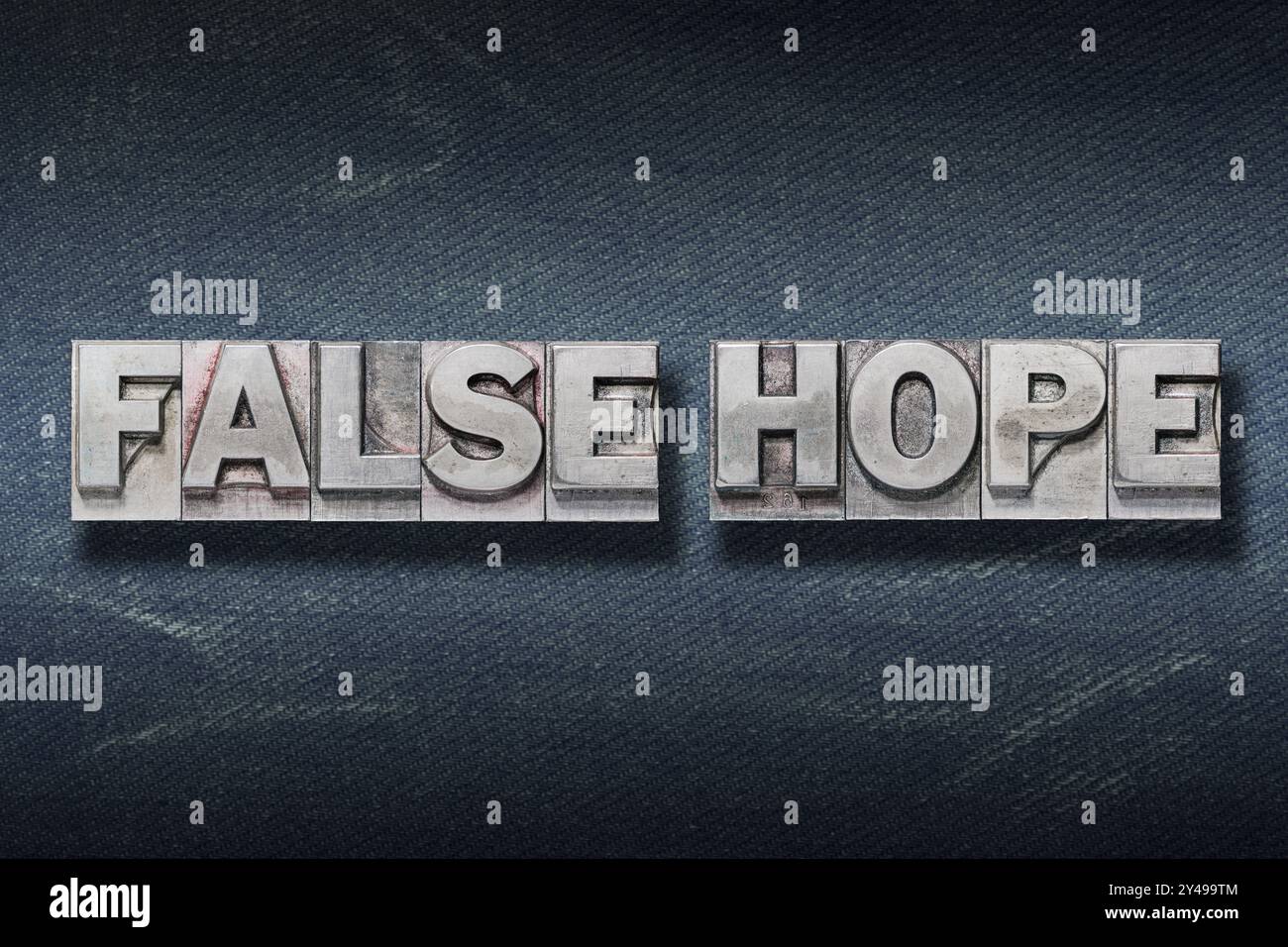 Falsche Hope-Phrase aus metallischem Buchdruck auf dunklem Jeanshintergrund Stockfoto