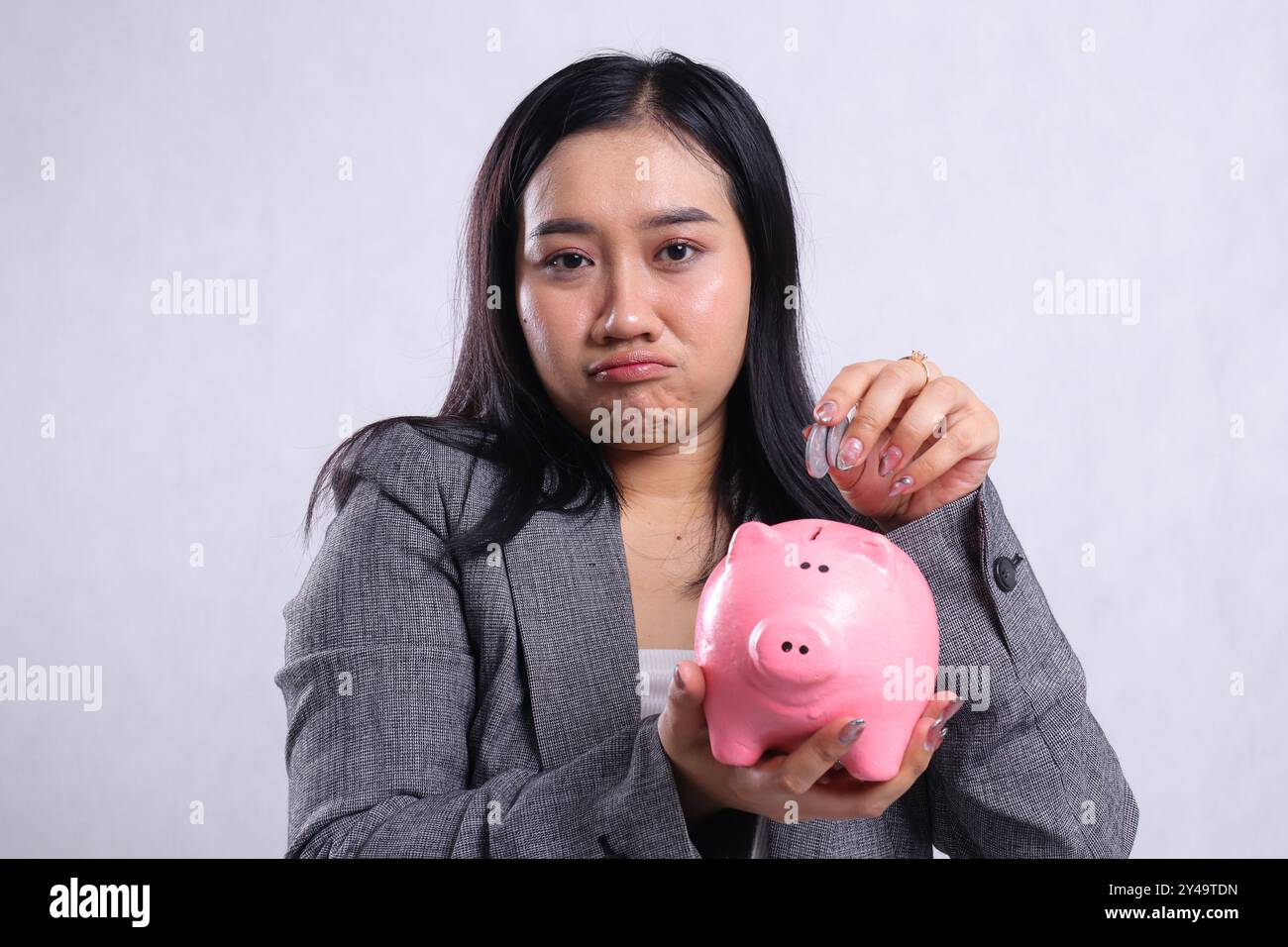 Nahaufnahme schöne junge Bürofrauen, die Münzen und Sparschwein für Alterseinsparungen tragen, tragen Anzug isoliert auf weißem Hintergrund. Werbung Stockfoto