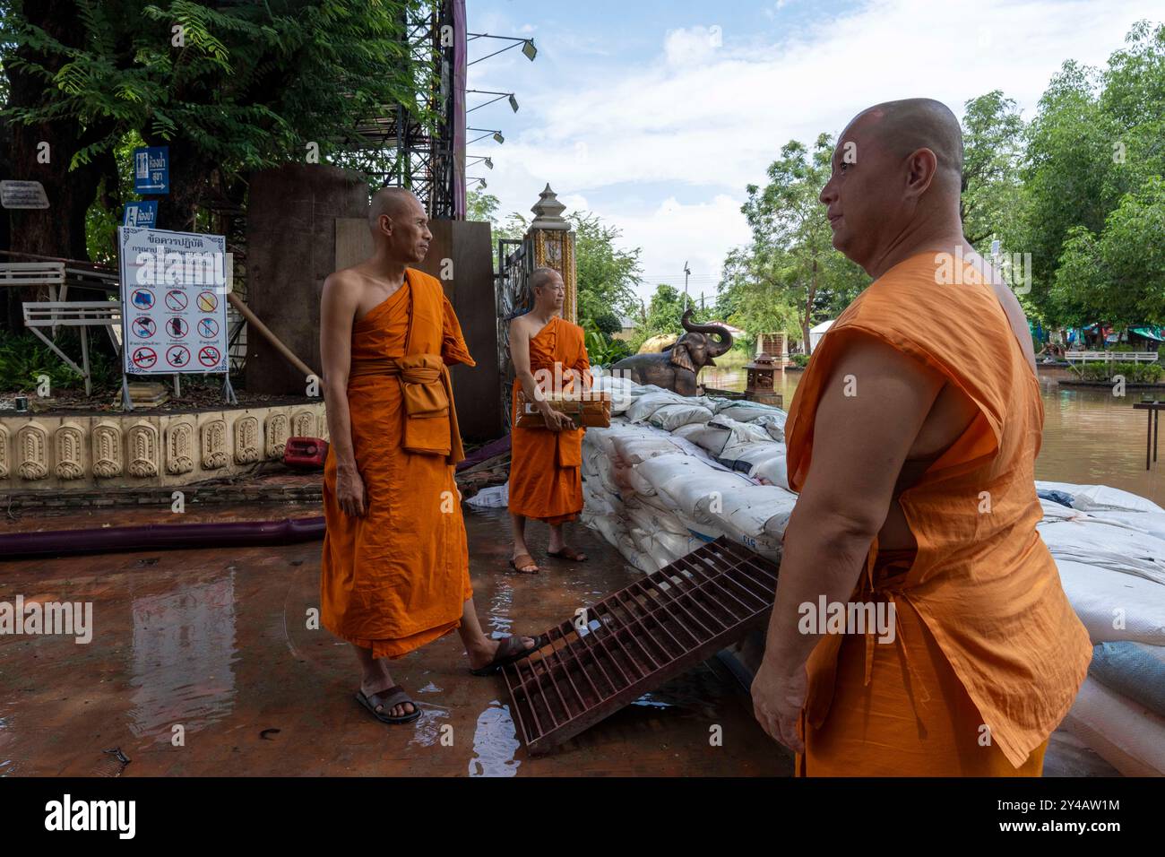 Nong Khai, Nong Khai, Thailand. September 2024. Buddhistische Mönche stehen hinter einer Sandsackbarriere, die das Hochwasser im Wat Pho Chai Tempel in Nong Khai, Thailand, zurückhält, der infolge des Überflusses des Mekong am 14. September 2024 überflutete. Mehrere andere Provinzen im Norden Thailands sind ebenfalls von den schlimmsten Überschwemmungen seit Jahrzehnten betroffen, die durch den Landfall von Super Taifun Yagi auf das südostasiatische Festland verursacht wurden. Seit August 2024 sind in Thailand mehr als 40 Menschen an den Folgen von Überschwemmungen gestorben, und Zehntausende sind betroffen. (Bild: © Adryel Ta Stockfoto