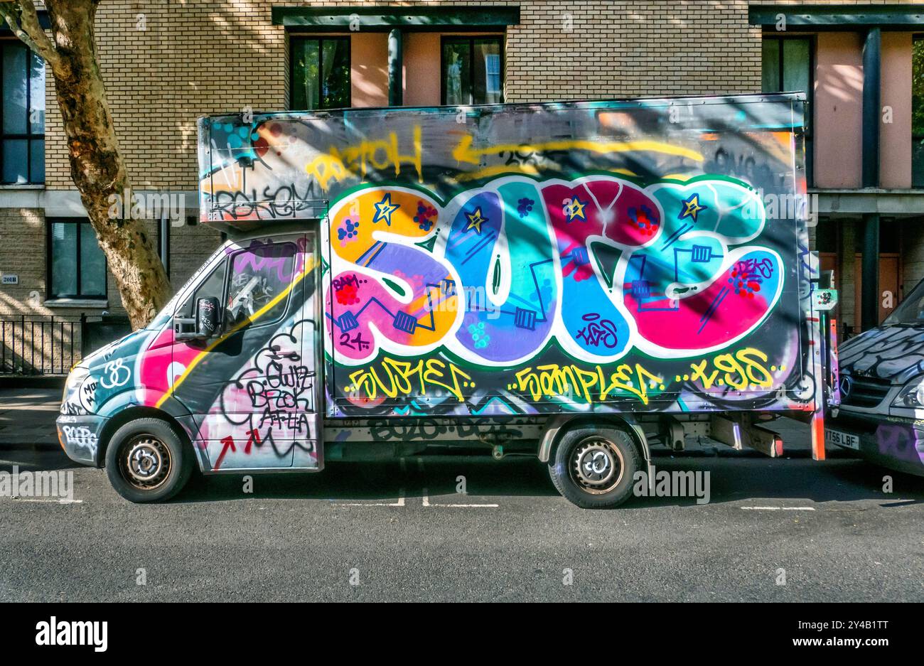 Mit Graffiti bedeckte Lieferwagen, die in der Arlington Road Camden Toen London, Großbritannien, geparkt sind Stockfoto