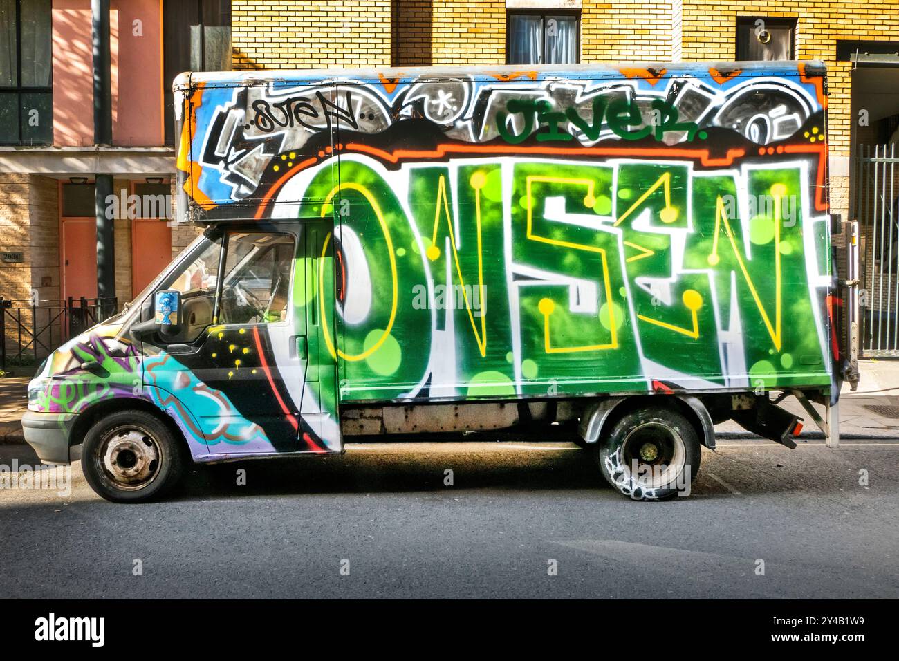 Mit Graffiti bedeckte Lieferwagen, die in der Arlington Road Camden Toen London, Großbritannien, geparkt sind Stockfoto