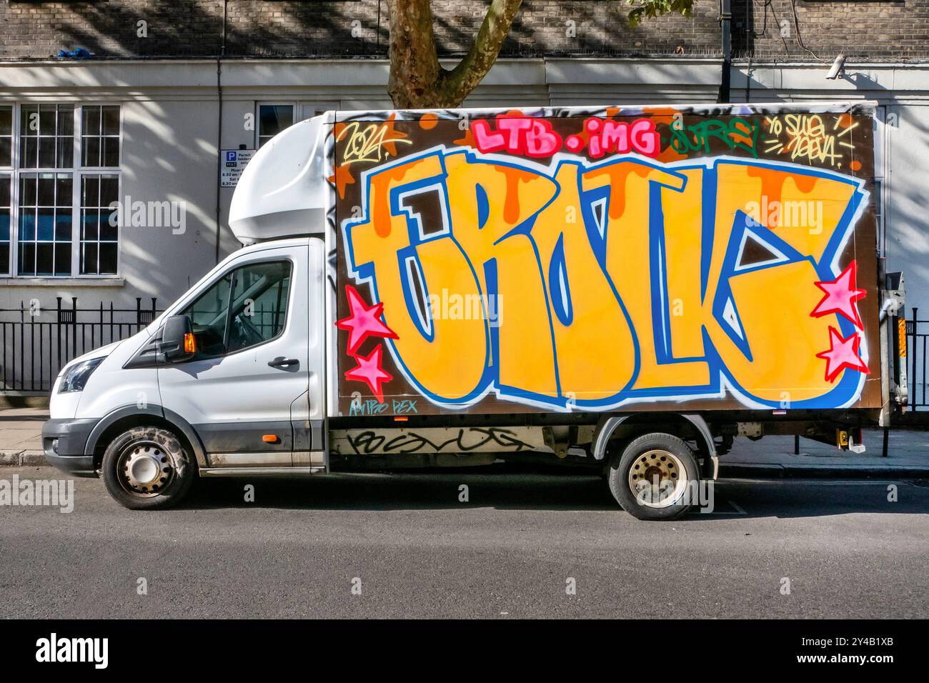 Mit Graffiti bedeckte Lieferwagen, die in der Arlington Road Camden Toen London, Großbritannien, geparkt sind Stockfoto