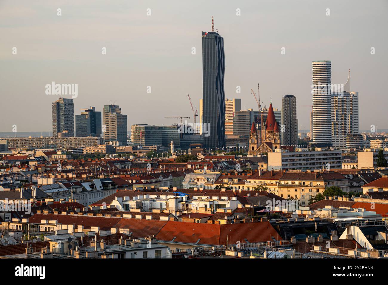 Panoramablick auf Wiens Stadtlandschaft, der den Kontrast zwischen modernen Wolkenkratzern und historischer Architektur zeigt. DC Tower und Donau City Complex Stockfoto