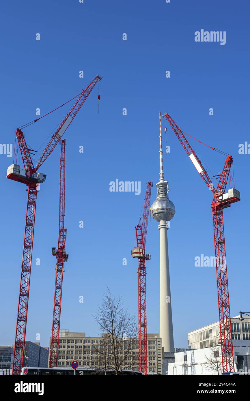 Der berühmte Berliner Fernsehturm mit vier roten Turmkränen Stockfoto