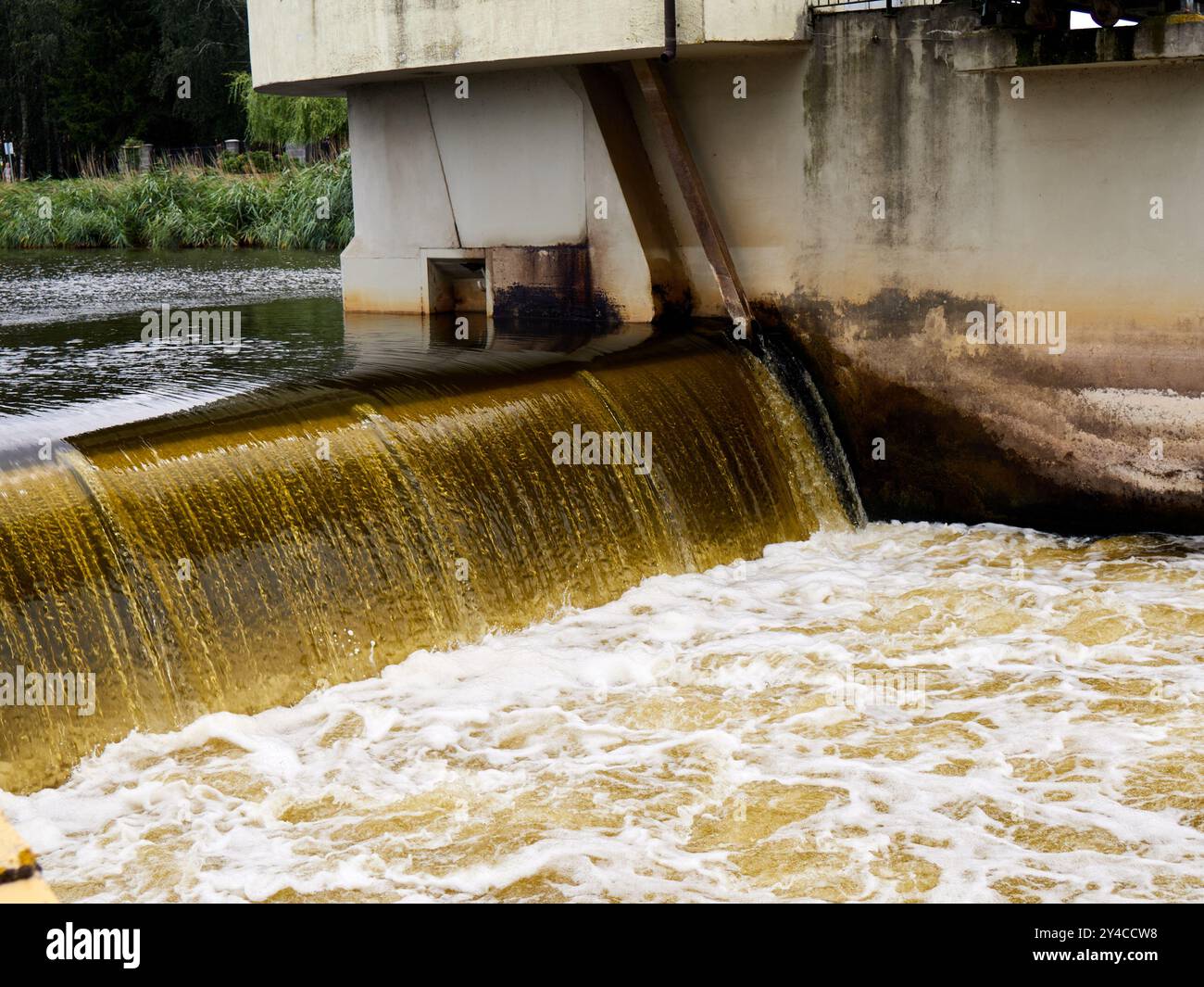 Wasser im Fluss, das durch ein Wehr fließt. Stockfoto