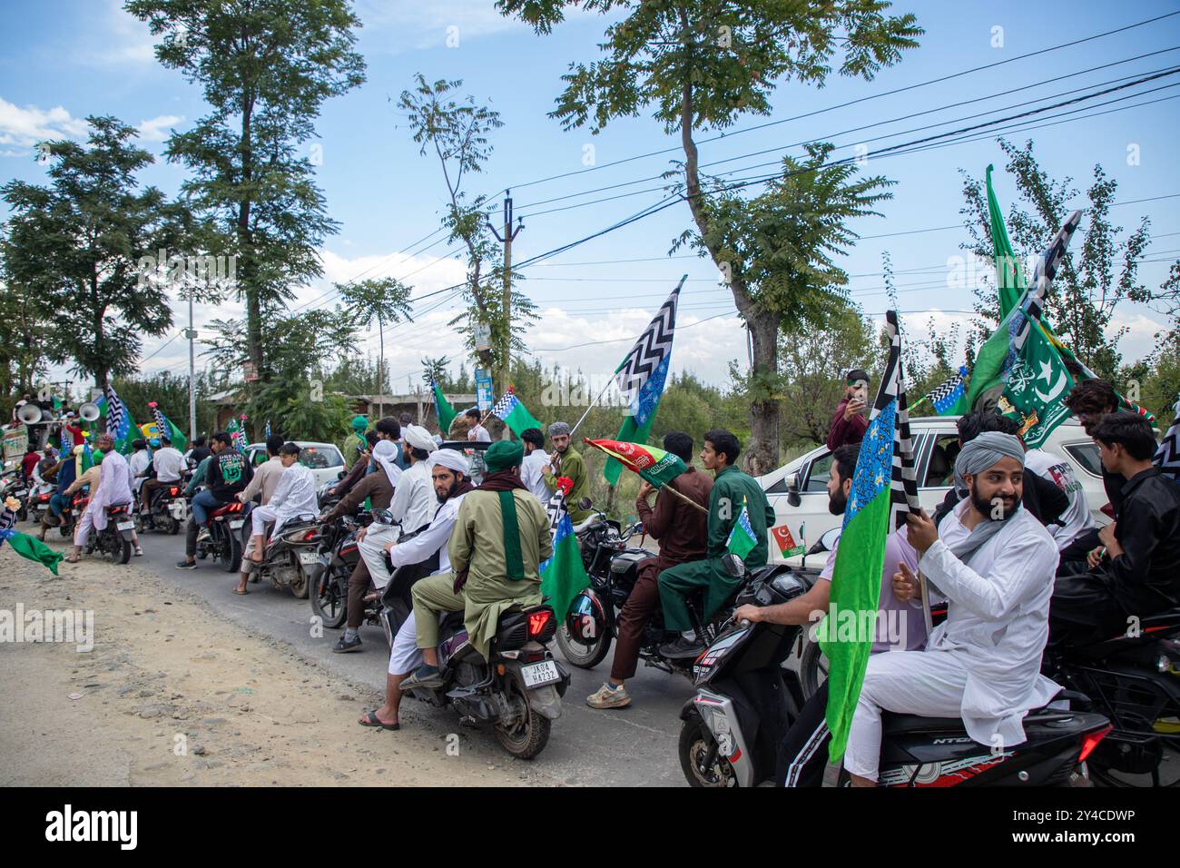 Srinagar, Indien. September 2024. Kaschmiri-Muslime halten islamische Fahnen, während sie an einer religiösen Prozession anlässlich der Eid-e-Milad teilnehmen, um den Geburtstag des Propheten Mohammed (PBUH) am Stadtrand von Srinagar zu gedenken. EID-e-Milad-un-Nabi, oder (Mawlid), ist das islamische fest, das den Geburtstag des Propheten Mohammed (PBUH) feiert, der am 12. Tag von Rabi-ul-Awwal, dem dritten Monat des islamischen Kalenders im Jahr 571 n. Chr., in der Saudi-arabischen Stadt Mekka geboren wurde (Foto: Faisal Bashir/SOPA Images/SIPA USA) Credit: SIPA USA/Alamy Live News Stockfoto