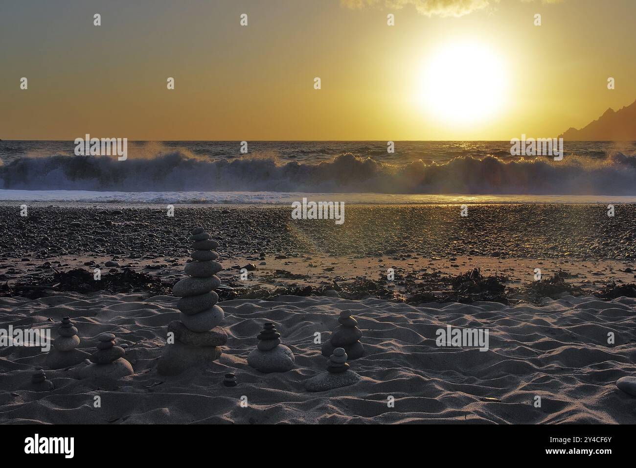 Landkunst vor den Surfwellen bei Sonnenuntergang am Strand von Porto, Korsika Stockfoto