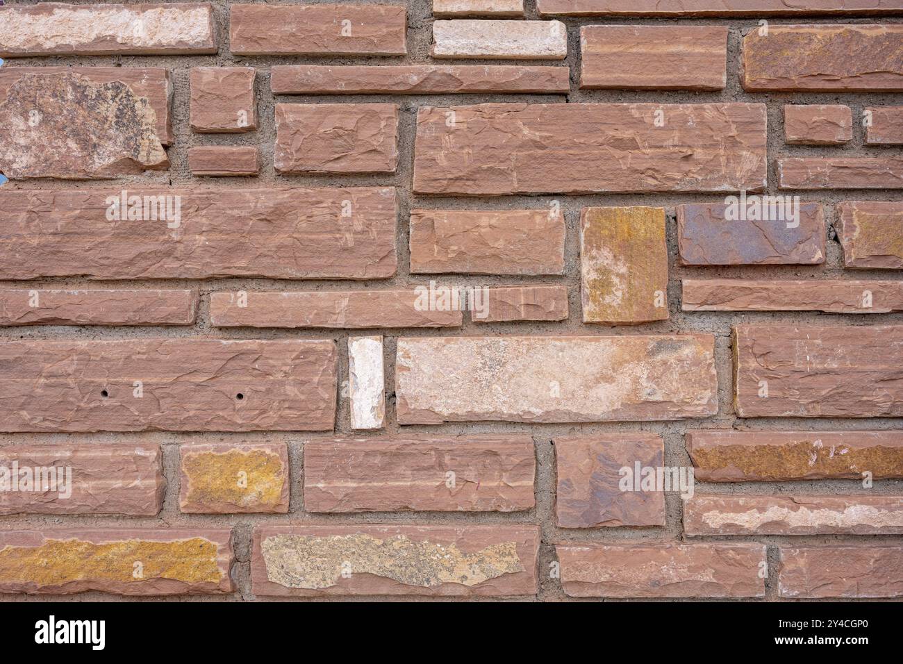 Hintergrund einer Mauer aus roten Sandsteinziegeln Stockfoto