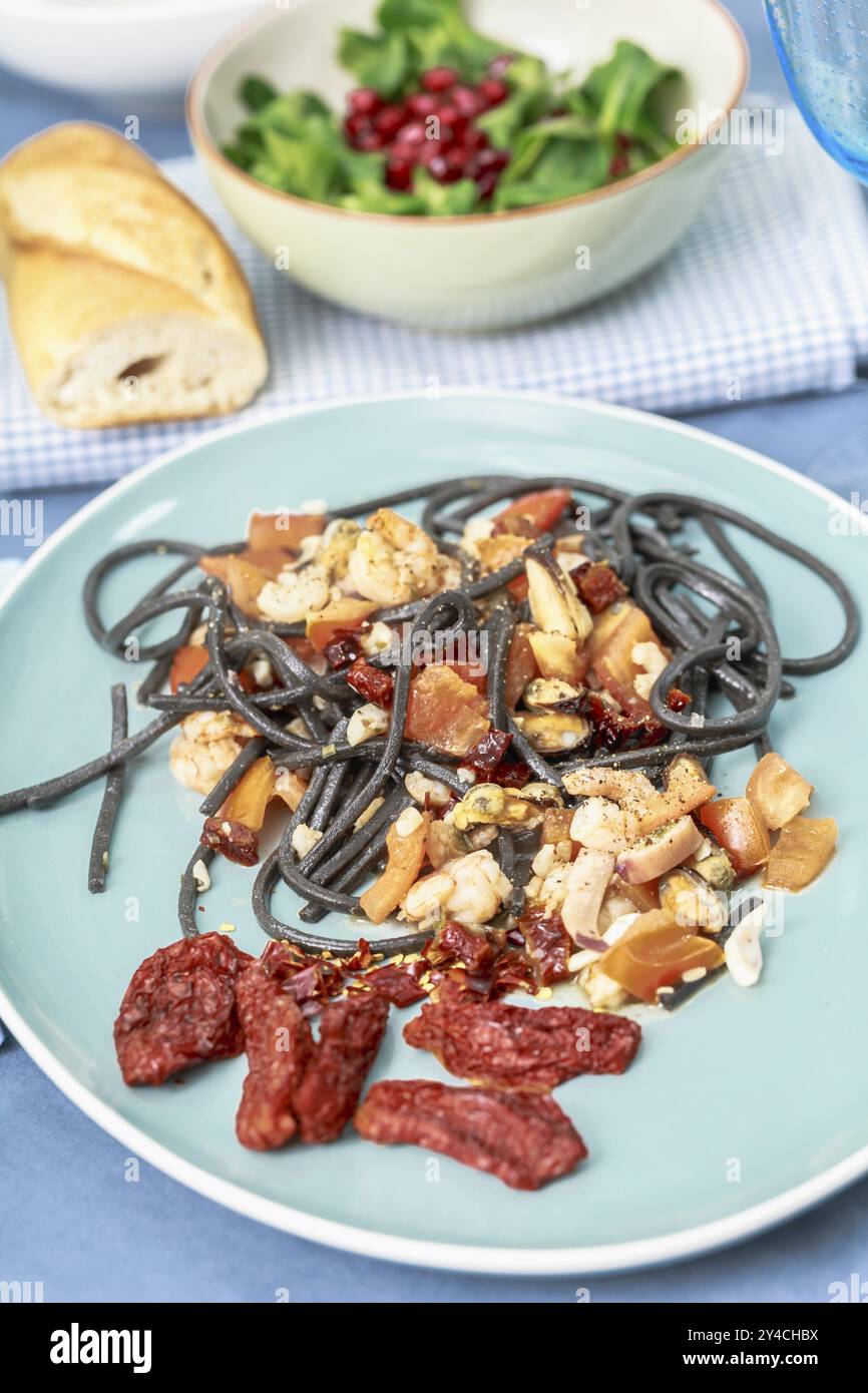 Spaghetti al nero di seppia mit Meeresfrüchten und Tomaten Stockfoto