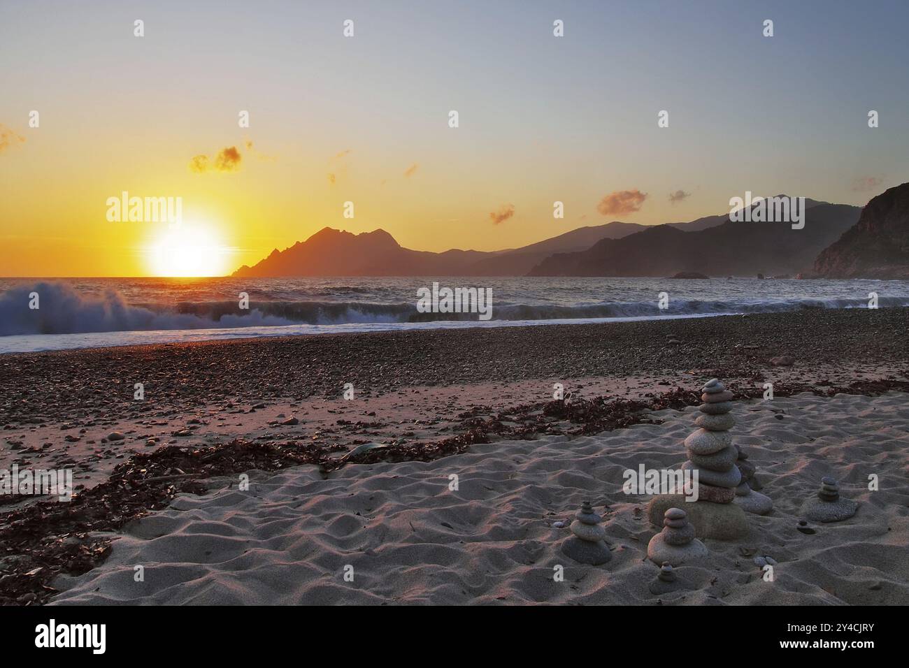 Landkunst vor den Surfwellen bei Sonnenuntergang am Strand von Porto, Korsika Stockfoto