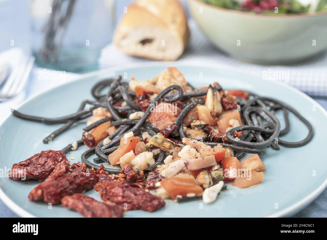 Spaghetti al nero di seppia mit Meeresfrüchten und Tomaten Stockfoto