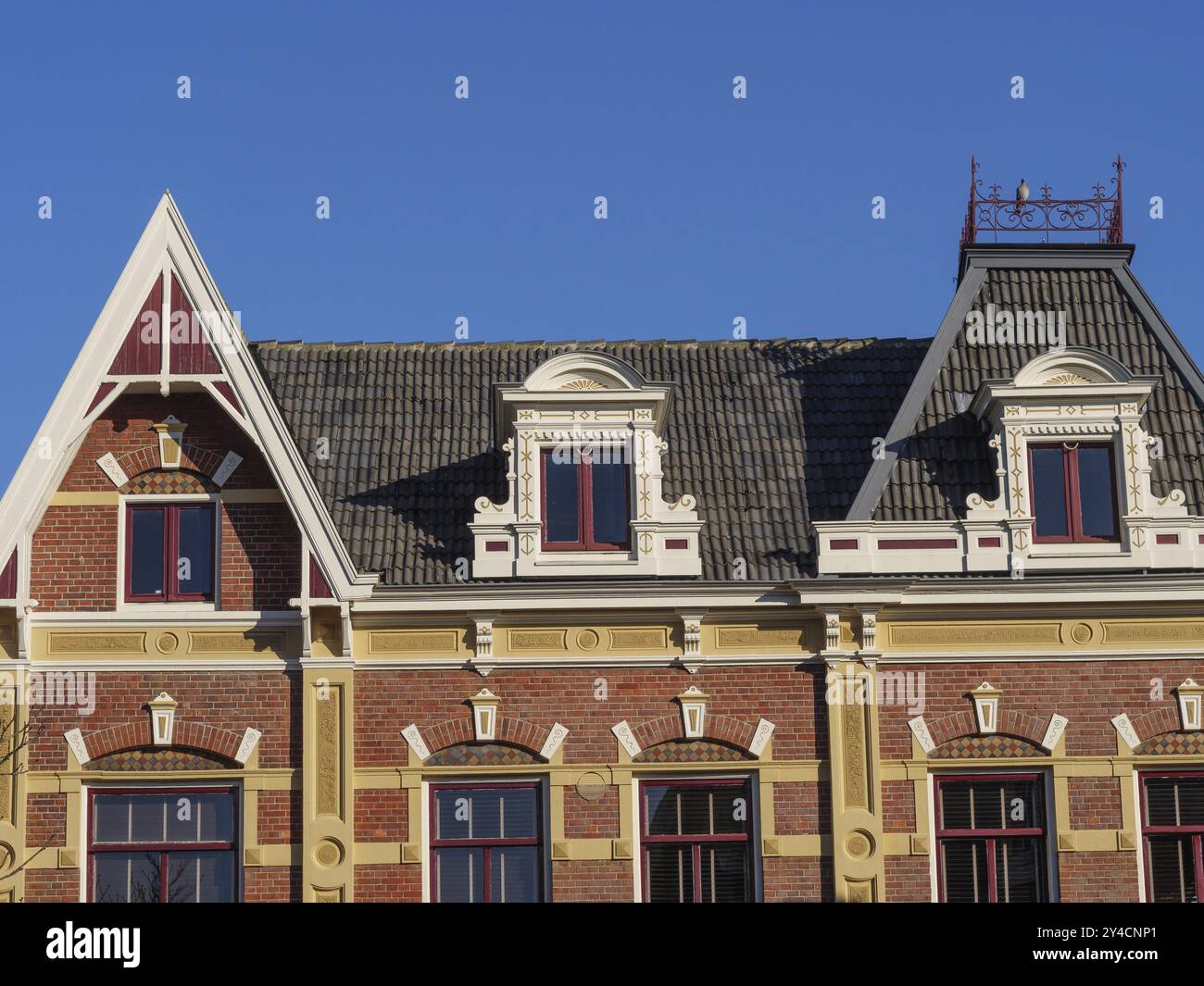 Historisches Gebäude mit aufwendigem Dach- und Fensterdesign unter blauem Himmel, winterswijk, niederlande Stockfoto