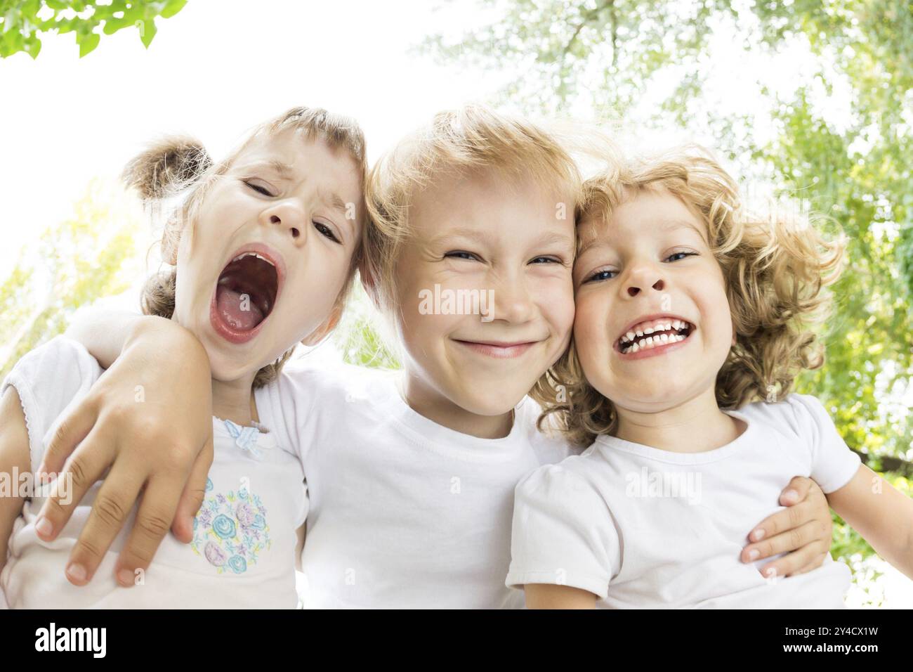 Porträt von glücklichen Kindern, die im Frühling im Freien dumme Gesichter machen. Fischaugenaufnahme Stockfoto