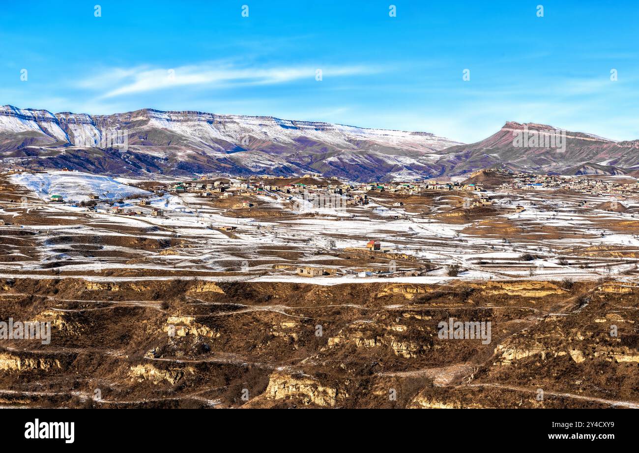 Das Dorf im Becken ist im Winter von hohen Bergen umgeben Stockfoto