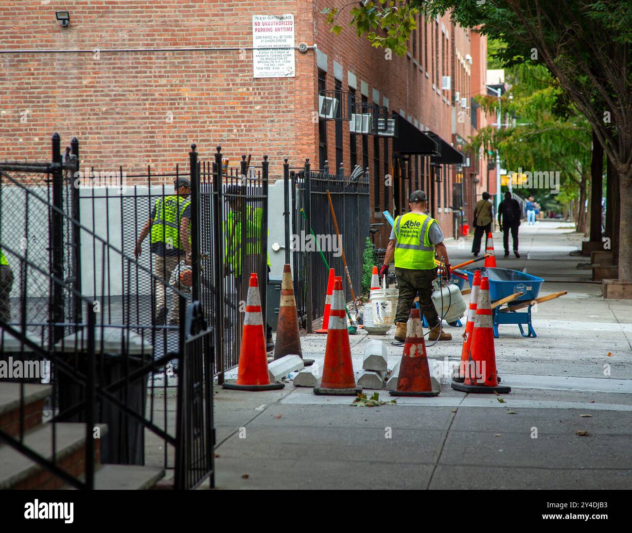 Arbeiter, die den Bürgersteig in der Gegend von Clinton Hill in Brooklyn, NY, umbauen Stockfoto