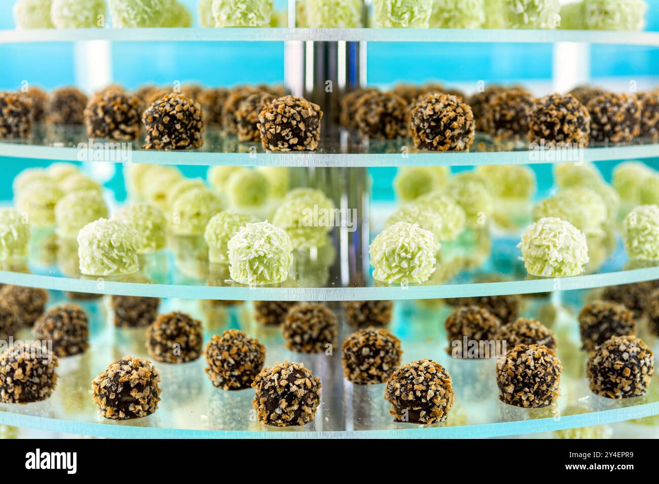 Verschiedene Gebäckstücke auf mehrstufigen Glasregalen in der Konditorei oder im Café. Stockfoto