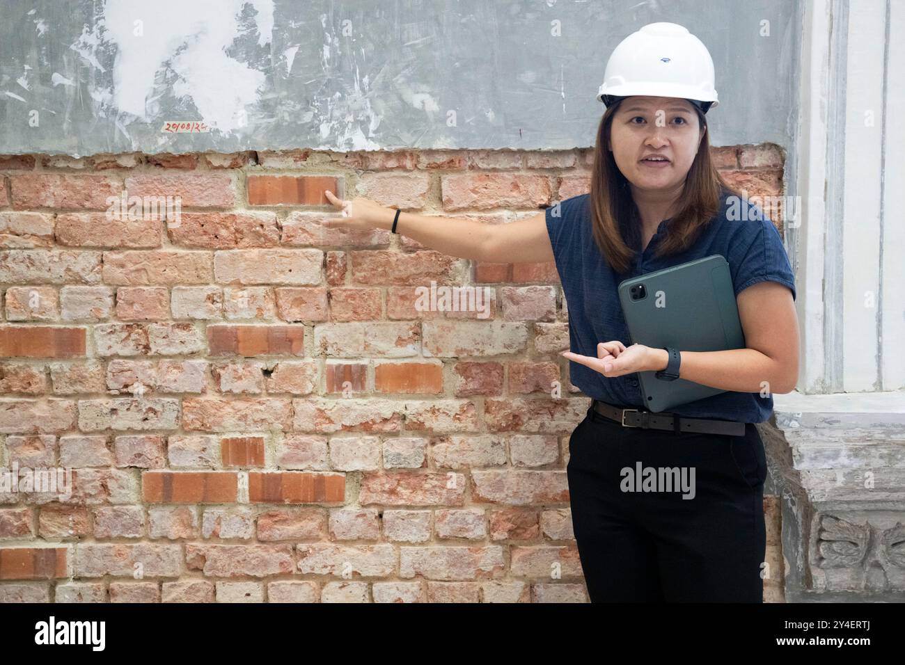Singapur, Nationalmuseum von Singapur in Singapur. September 2024. Ein Ingenieur erklärt den Unterschied zwischen den für die Restaurierung verwendeten Feuersteinen aus der modernen Zeit und den ursprünglichen Ziegeln, da im National Museum of Singapore am 17. September 2024 Restaurierungsarbeiten durchgeführt werden. Das Nationalmuseum von Singapur wird derzeit renoviert, um den allgemeinen Verschlechterungsbedingungen der Gebäude aufgrund von Abnutzung Rechnung zu tragen. Quelle: Dann Chih Wey/Xinhua/Alamy Live News Stockfoto