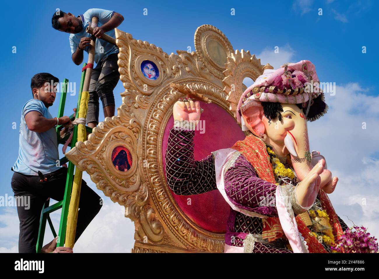 Männer demontieren einen Wagen mit einer Statue des hinduistischen Elefantengottes Ganesh vor dem Trad. Tauchen Sie ein in das Arabische Meer während des Ganesh Festivals; Mumbai, Indien Stockfoto