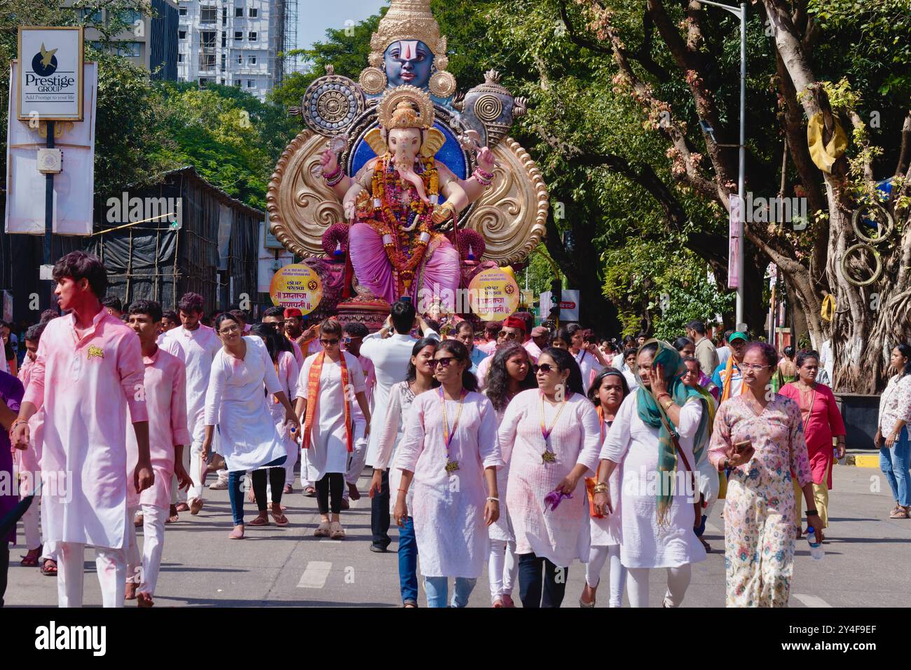 Mumbai, Indien: In einer Prozession während des jährlichen Ganesh Festivals läuft eine Menschenmenge vor einem Wagen mit einer großen Statue des Hinduelefantengottes Ganesh Stockfoto