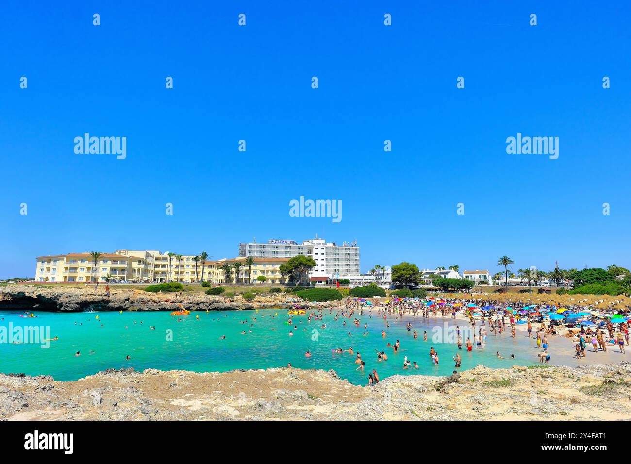 Spanien, Balearen, Menorca: Touristenströme am weißen Sandstrand von Cala en Bosc. Übertourismus Stockfoto