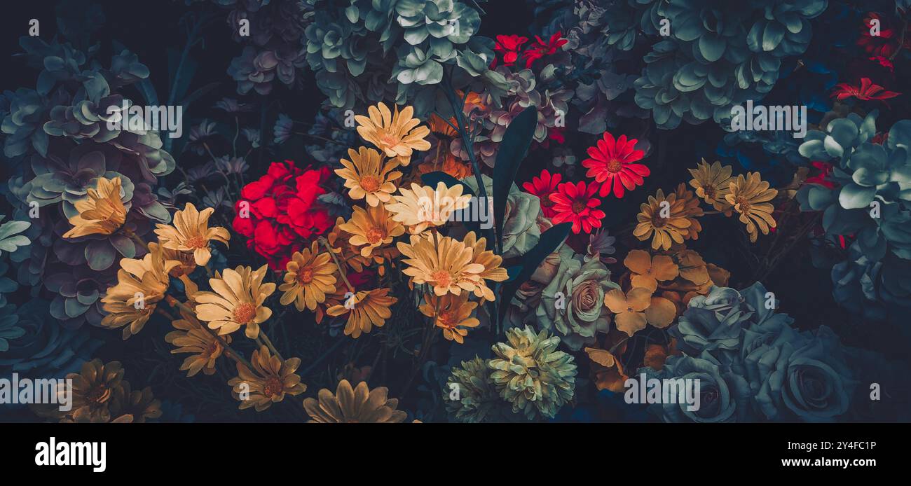 Eine Nahaufnahme von Vintage-Kunstblumen in einer dunklen und gedämpften Farbpalette. Stockfoto