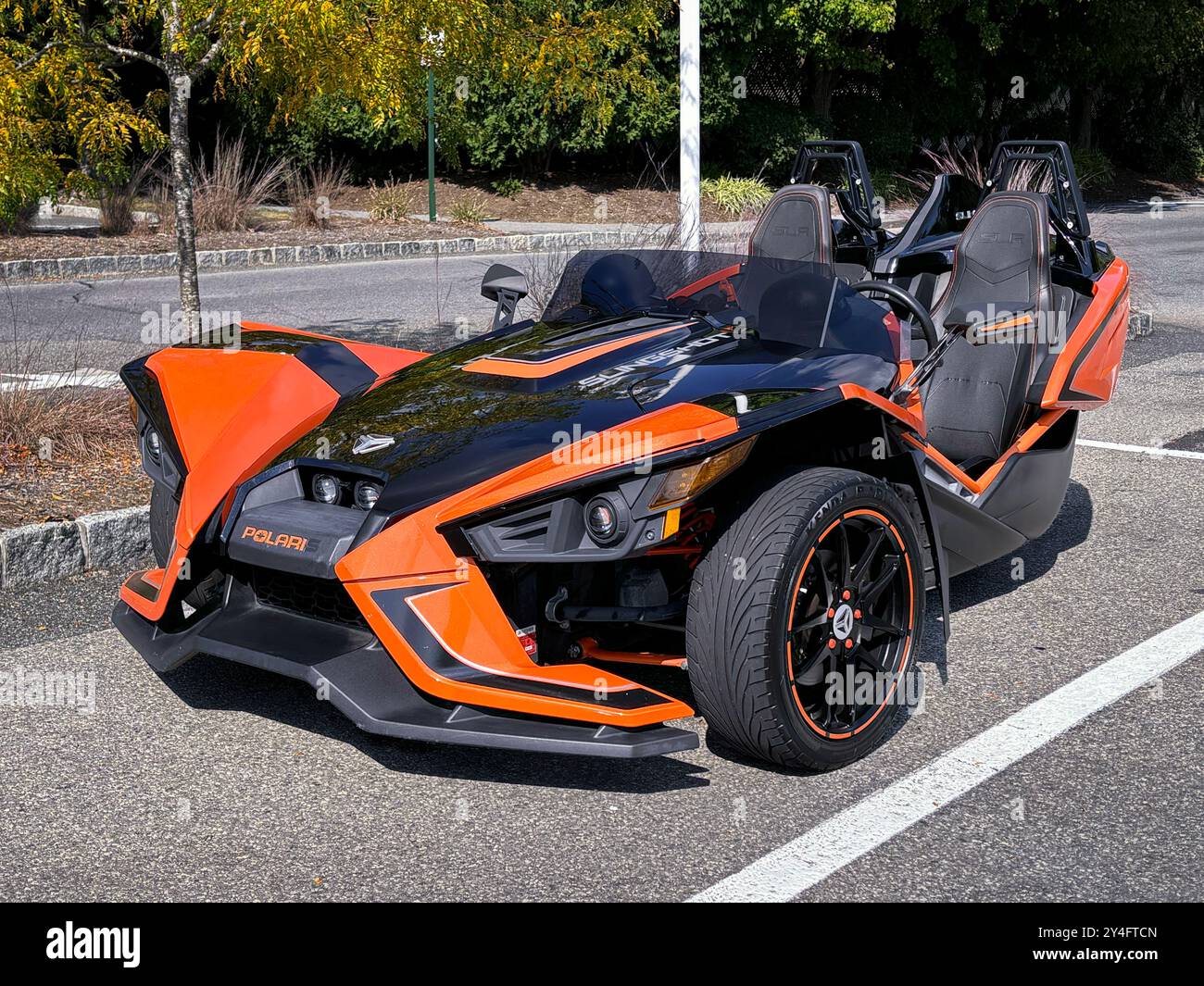 Ein orangefarbener und schwarzer Polaris Slingshot SLR-Roadster mit 3 Rädern parkt im Towne Center in Somers in Westchester, New York. Stockfoto