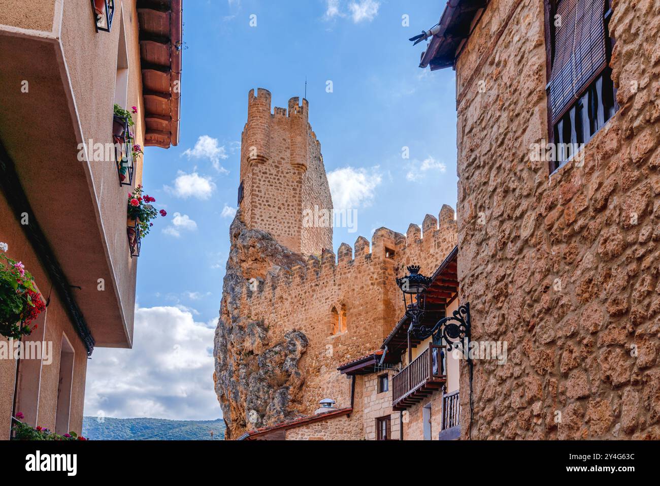 Frías, Spanien. August 2024. Beeindruckender Blick auf einen Verteidigungsturm, der über den traditionellen Gebäuden der Stadt hängt Stockfoto