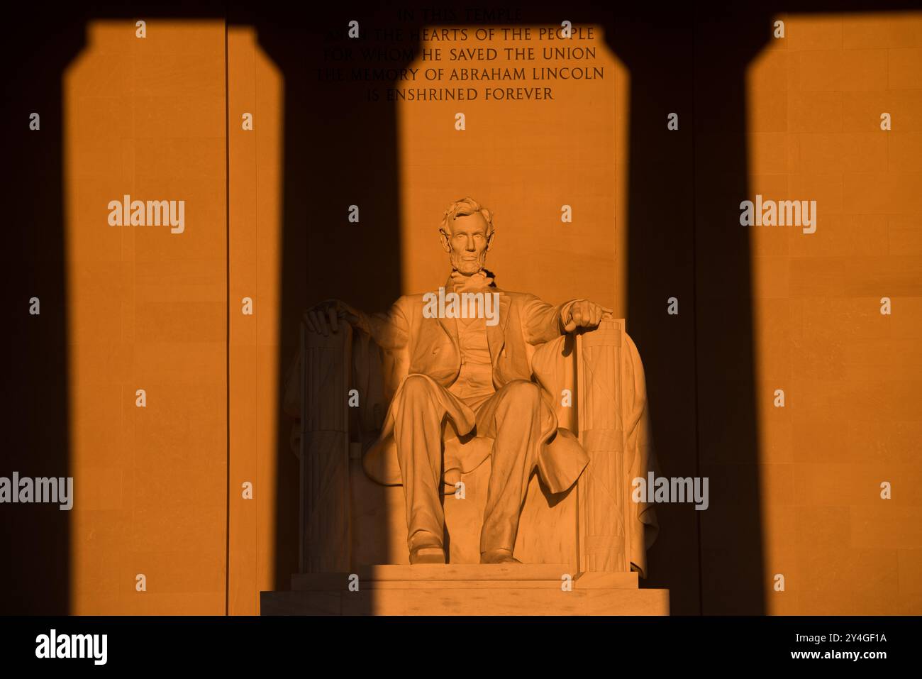 Lincoln Memorial Abraham Lincoln Statue Washington DC // WASHINGTON DC – die Statue von Abraham Lincoln im Lincoln Memorial wird unmittelbar nach Sonnenaufgang von natürlichem goldenem Sonnenlicht beleuchtet. Dieser Lichteffekt, der rund um die Frühlings- und Herbstnachtgleiche sichtbar ist, unterstreicht die Pracht des Denkmals, wenn die Sonne durch den östlichen Eingang scheint. Das Lincoln Memorial befindet sich in der National Mall und ist eines der berühmtesten Denkmäler der USA. Hinweis: Farbe und Beleuchtung sind natürlich. Stockfoto