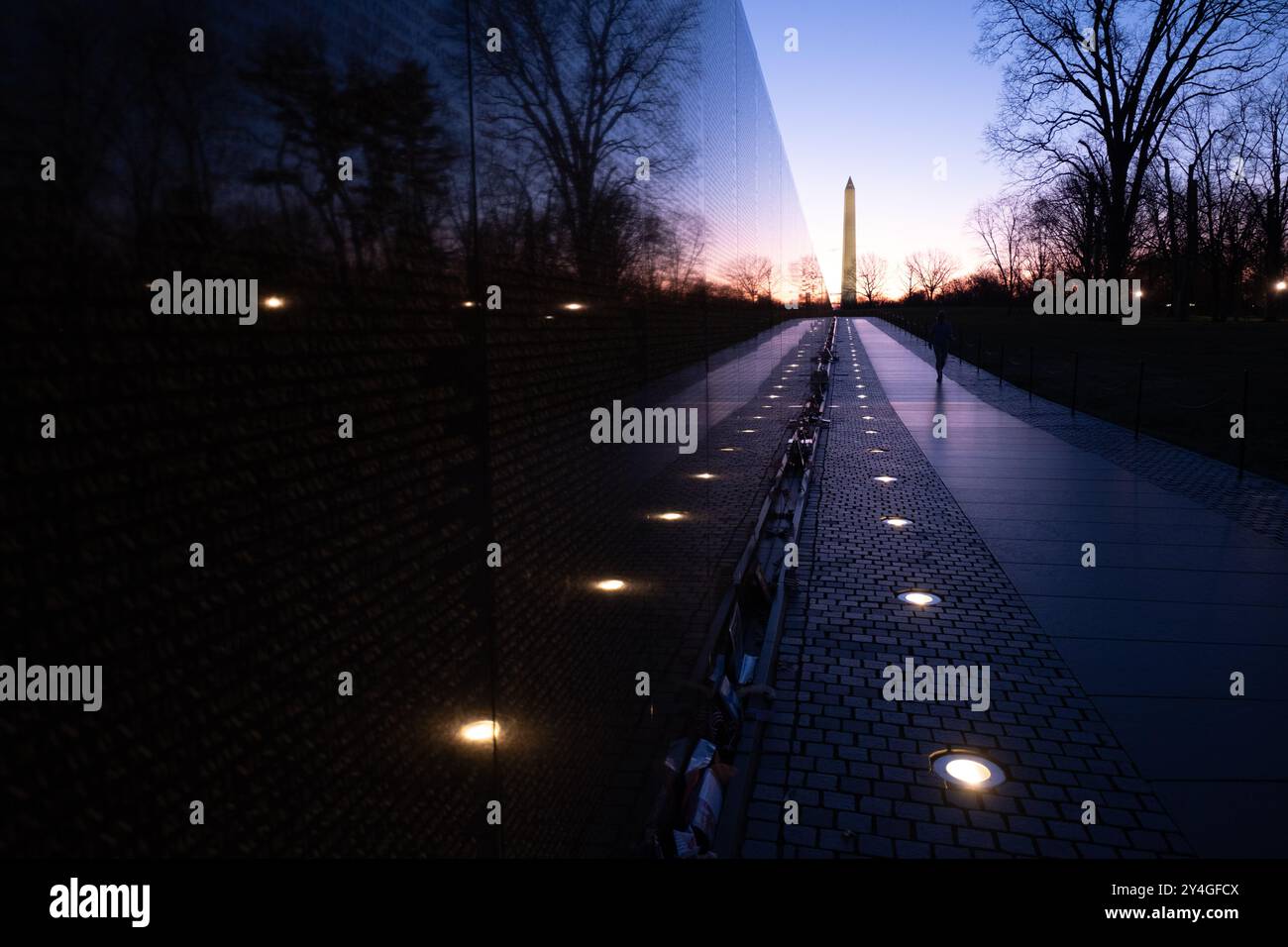 Vietnam Veterans Memorial Washington DC // WASHINGTON DC – das Vietnam Veterans Memorial und das Washington Monument stehen unter dem dramatischen Himmel vor der Dämmerung in Washington DC. Das berühmte Denkmal ehrt US-Soldaten, die im Vietnamkrieg gekämpft haben. Das Washington Monument, ein Obelisk, der George Washington Washington gewidmet ist, ist eines der bekanntesten Wahrzeichen der Stadt. Stockfoto