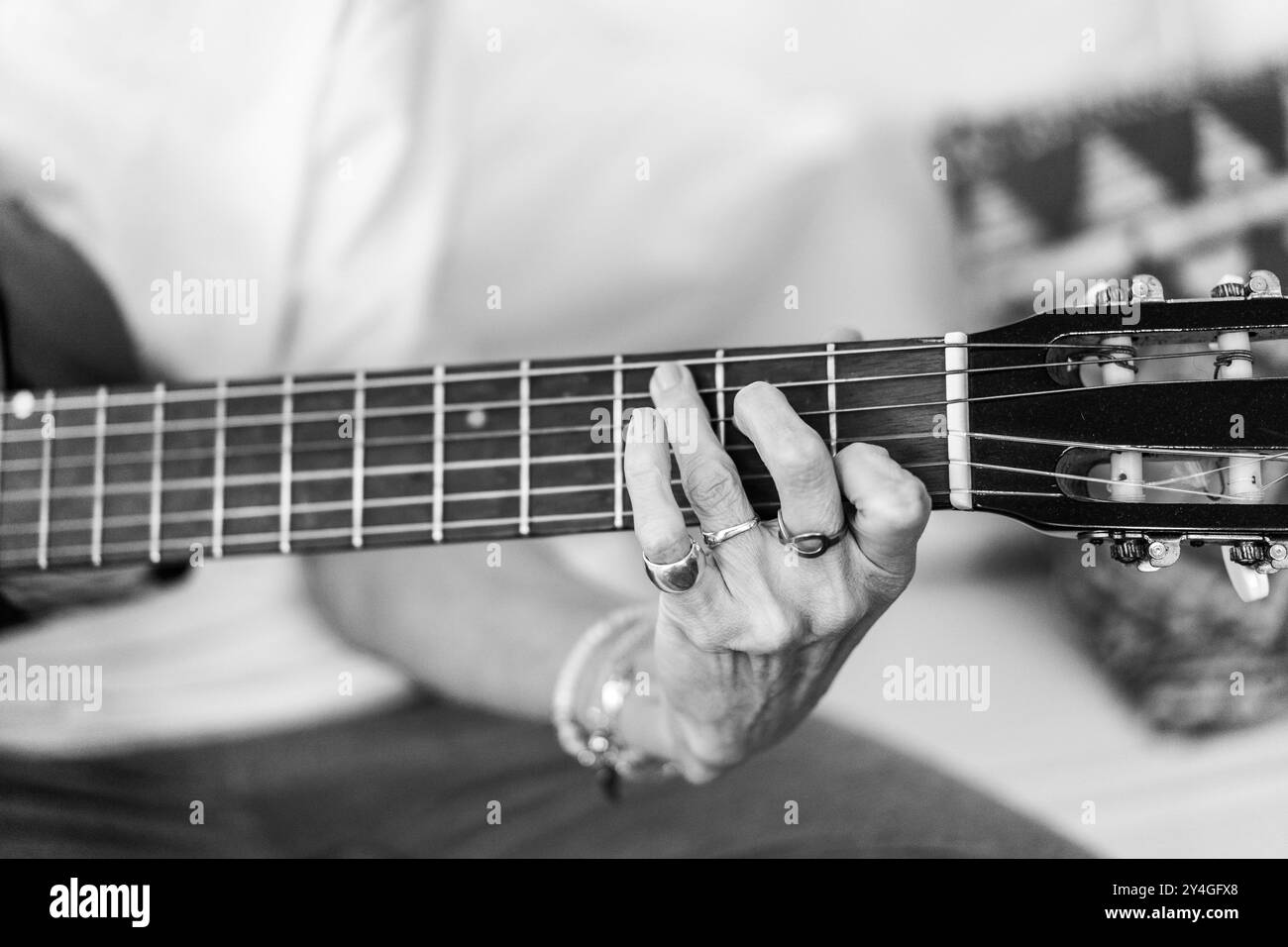 Detaillierte Ansicht der Hände einer Frau, während sie Gitarre spielt Stockfoto