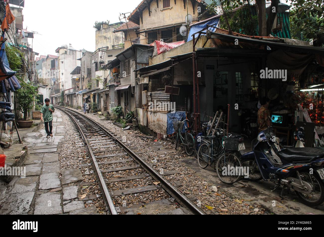 Train Street Hanoi Vietnam // HANOI, Vietnam — die Gleise führen durch ein altes Viertel in Hanoi, wobei die Gleise sehr nahe an die umliegenden Gebäude liegen. Die berühmte Bahnstraße ist ein bekannter Teil der Stadt, wo der Zug nur wenige Zentimeter von Häusern und Geschäften in der engen Gasse entfernt vorbeifährt. Stockfoto