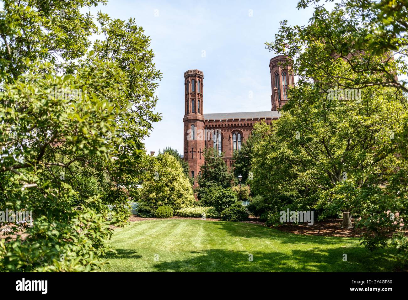 WASHINGTON DC, Vereinigte Staaten — das Smithsonian Castle, das hier vom Moongate Garden aus gesehen wird, wurde 1855 fertiggestellt und dient als Verwaltungssitz der Smithsonian Institution. Das vom Architekten James Renwick Jr. im Stil des Norman Revival entworfene Gebäude ist aus rotem Sandstein aus Seneca Creek, Maryland, gebaut. Das Schloss ist an der Südseite der National Mall verankert und beherbergt eine Dauerausstellung über die Geschichte und Sammlungen des Smithsonian. Stockfoto