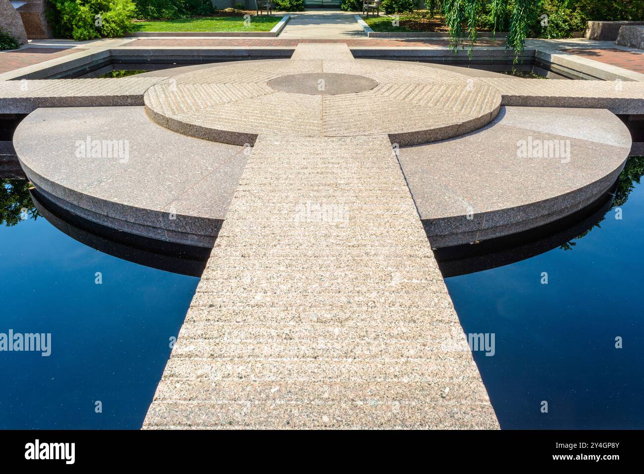 WASHINGTON DC – der Moongate Garden befindet sich zwischen der Freer Gallery of Art und der Arthur M. Sackler Gallery auf dem Gelände von Smithsonian. Dieser asiatisch inspirierte Garten verfügt über Granitskulpturen und einen reflektierenden Pool. Der Garten ist Teil des größeren Enid A. Haupt Gartenkomplexes neben dem Smithsonian Castle. Der Moongate Garden wurde entworfen, um die asiatischen Kunstsammlungen der Museen zu ergänzen, und enthält traditionelle chinesische Architekturelemente, darunter das namensgebende runde Mondtor. Der ruhige Ort bietet Besuchern eine besinnliche Umgebung inmitten der lebhaften Atmosphäre der National Mall. Der Garten Stockfoto