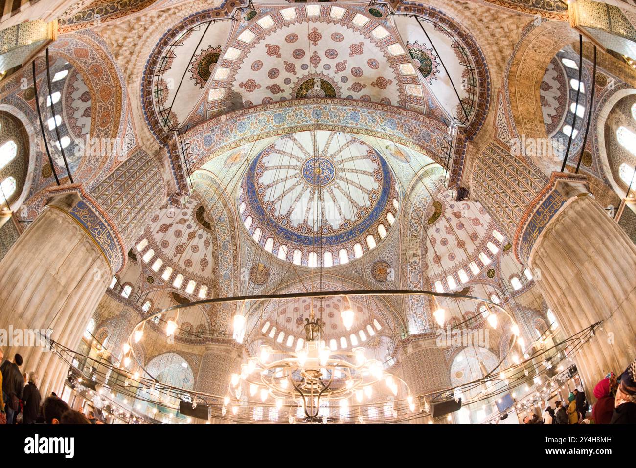 ISTANBUL, Türkei: Die Wände und die Decke des Hauptgebetsaals der Sultan-Ahmed-Moschee (Blaue Moschee) sind mit komplizierten islamischen Dekorationen bedeckt. Die Moschee wurde 1616 fertiggestellt und verfügt über eine umfangreiche Verwendung von handbemalten Fliesen und Kalligrafie in ihrer Innenarchitektur. Der Raum zeigt die Höhe der osmanischen architektonischen und dekorativen Leistung während des frühen 17. Jahrhunderts. Stockfoto