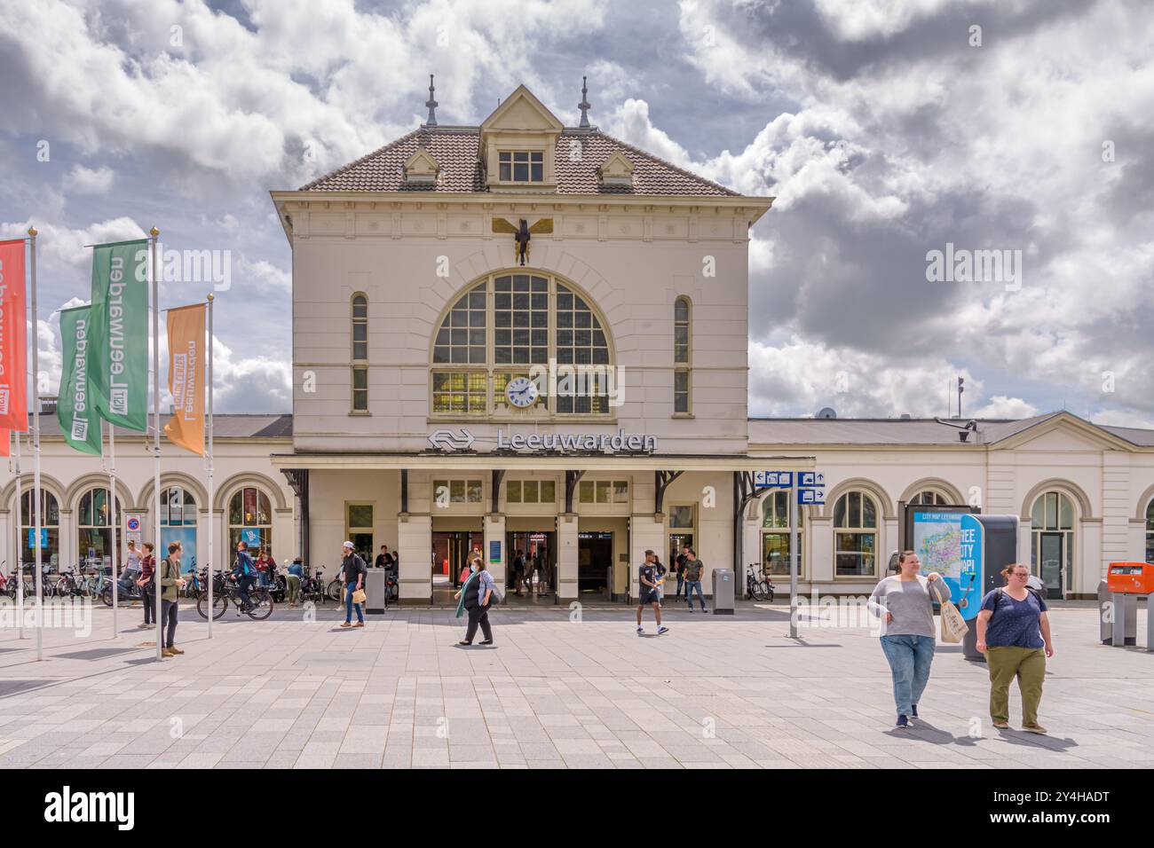 Leeuwarden, Niederlande - 12. Juni 2021: Vorplatz des Bahnhofs Leeuwarden an einem sonnigen bewölkten Tag, mit dem schönen weißen Bahnhofsgebäude Stockfoto