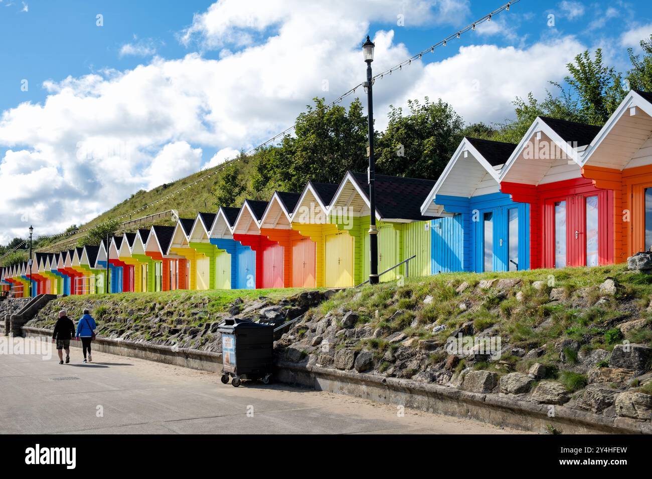 Scarborough, Großbritannien. Eine Reihe von farbenfrohen Strandchalets oder Hütten an der Promenade an der North Bay. Eine traditionelle englische Küstenszene Stockfoto