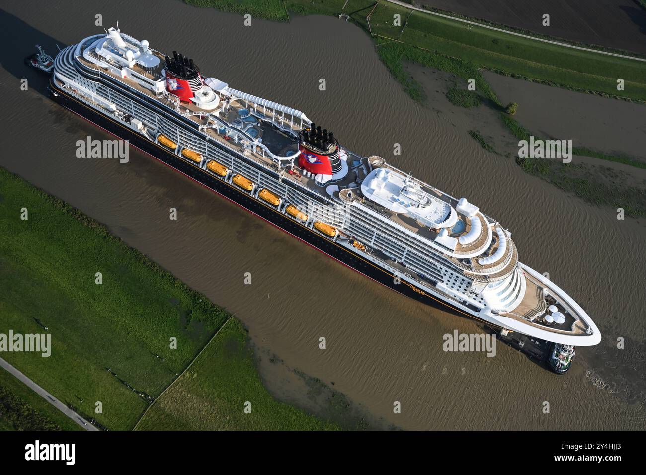 Meyer Werft überführt neues Kreuzfahrtschiff Disney Treasure das neugebaute Kreuzfahrtschiff Disney Treasure hat die Meyer Werft verlassen und wird mit Schleppern über die Ems gezogen. Die Werft begann heute Vormittag mit der Überführung des rund 340 Meter langen Kreuzfahrtschiffes über die Ems von Papenburg Richtung Eemshaven. Papenburg Niedersachsen Deutschland *** Meyer Werft übergibt neues Kreuzfahrtschiff Disney Treasure das neu gebaute Kreuzfahrtschiff Disney Treasure hat die Meyer Werft verlassen und wird mit Schleppbooten über die Ems gezogen, die die Werft heute Morgen mit dem Transfer von begonnen hat Stockfoto