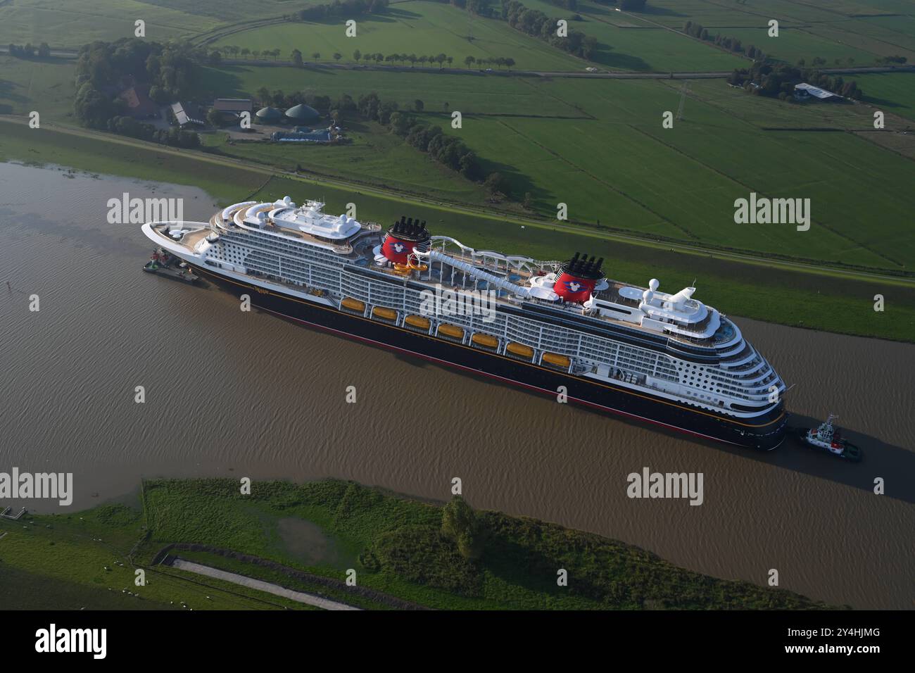 Meyer Werft überführt neues Kreuzfahrtschiff Disney Treasure das neugebaute Kreuzfahrtschiff Disney Treasure hat die Meyer Werft verlassen und wird mit Schleppern über die Ems gezogen. Die Werft begann heute Vormittag mit der Überführung des rund 340 Meter langen Kreuzfahrtschiffes über die Ems von Papenburg Richtung Eemshaven. Papenburg Niedersachsen Deutschland *** Meyer Werft übergibt neues Kreuzfahrtschiff Disney Treasure das neu gebaute Kreuzfahrtschiff Disney Treasure hat die Meyer Werft verlassen und wird mit Schleppbooten über die Ems gezogen, die die Werft heute Morgen mit dem Transfer von begonnen hat Stockfoto