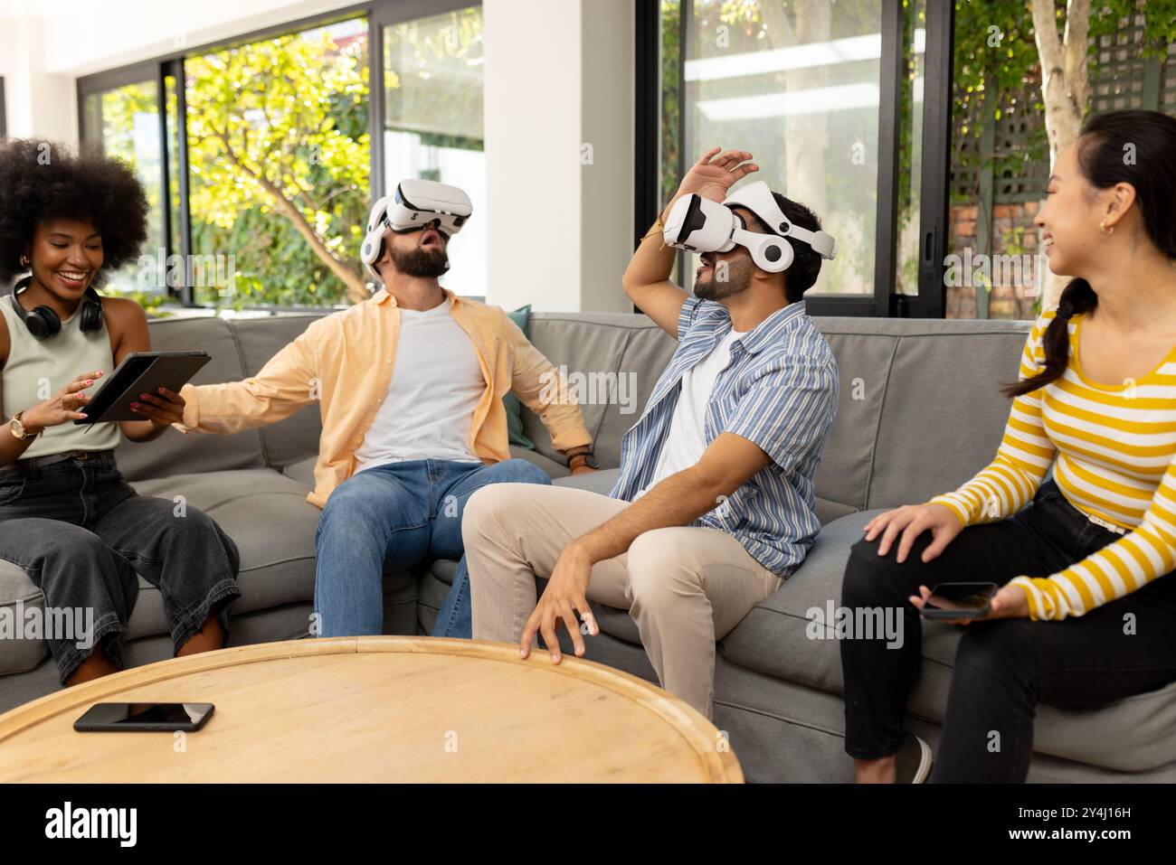 Mit VR-Headsets genießen junge Freunde gemeinsam Virtual-Reality-Spiele Stockfoto
